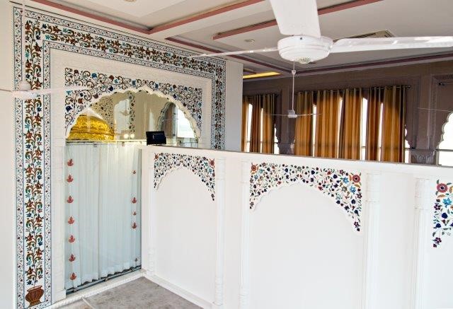 Given that the interior of the temple would see a high volume of traffic each day, it was important to find a building material that would be easy to clean and maintain in good condition over time. What’s more, Sikh practitioners typically sing hymns during religious services at the temple so it was essential that the new space have excellent acoustics. The selection of Corian<sup>®</sup> helped to overcome these challenges. The advanced surface was chosen over marble, a stone that is traditionally used in religious architecture – for example, the decorative marble inlay seen at the Taj Mahal in Agra. The team working on the Kutia Tapstan temple in Tuto Mazara preferred to use Corian<sup>®</sup> since marble inlay work is time-consuming and because of the porosity of marble. Singh’s plans called for over 3,000 square feet of surface to be clad with Corian<sup>®</sup> Glacier White, which was used together with Agra Red sandstone and mother-of-pearl inlay on the walls in the hall of the temple. Components in Glacier White featured carved patterns that resembled floral motifs that were designed by the architect and which drew inspiration from religious texts.